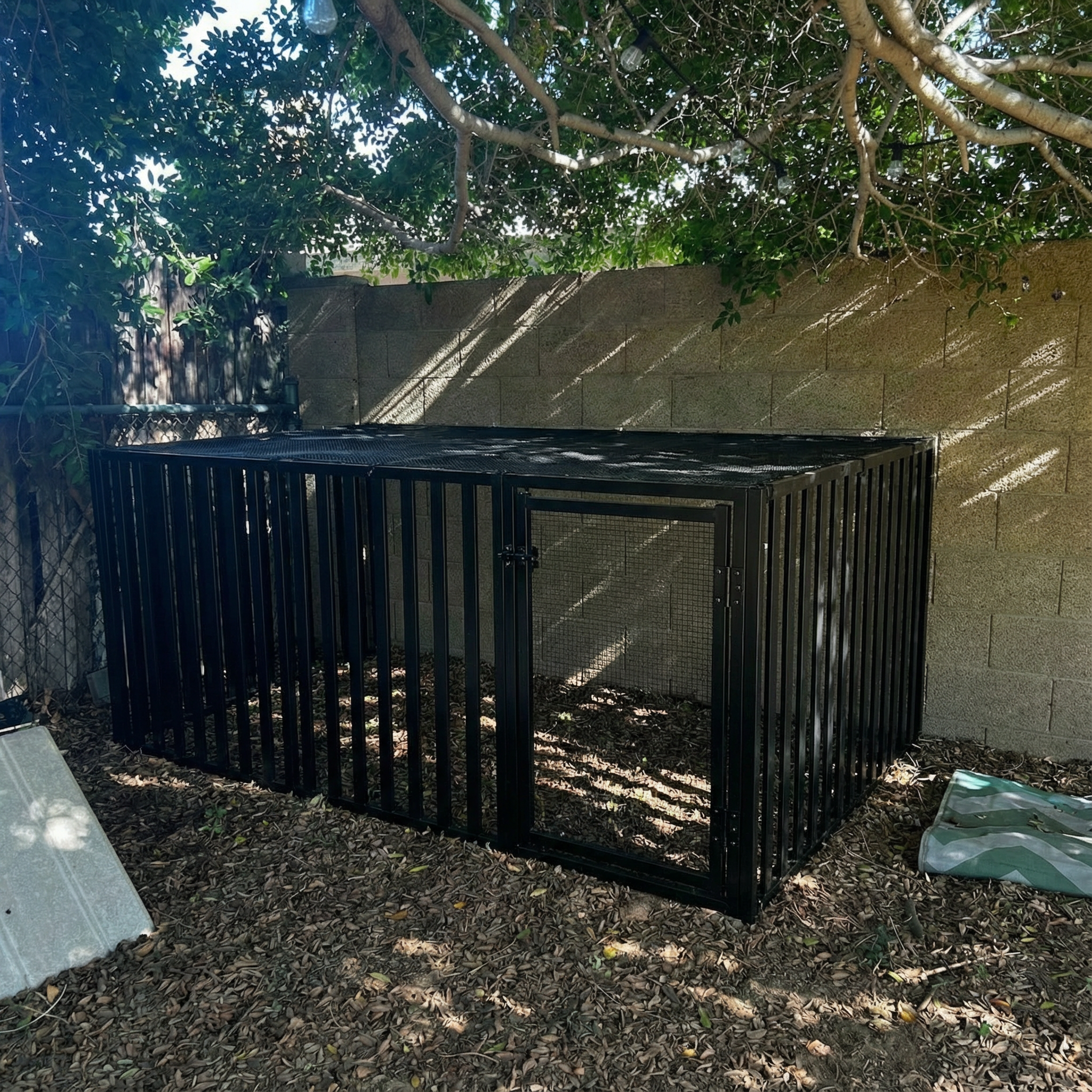 edit this image to remove the pallet fencing and place a chicken coop in this space which is constructed of 4 ft. H x 6 ft. W Black Aluminum Pre-Assembled Flat Top Spaced Picket Fence Panel black with black 1/2 hardware cloth on top of the fencing make a door gate in the coop