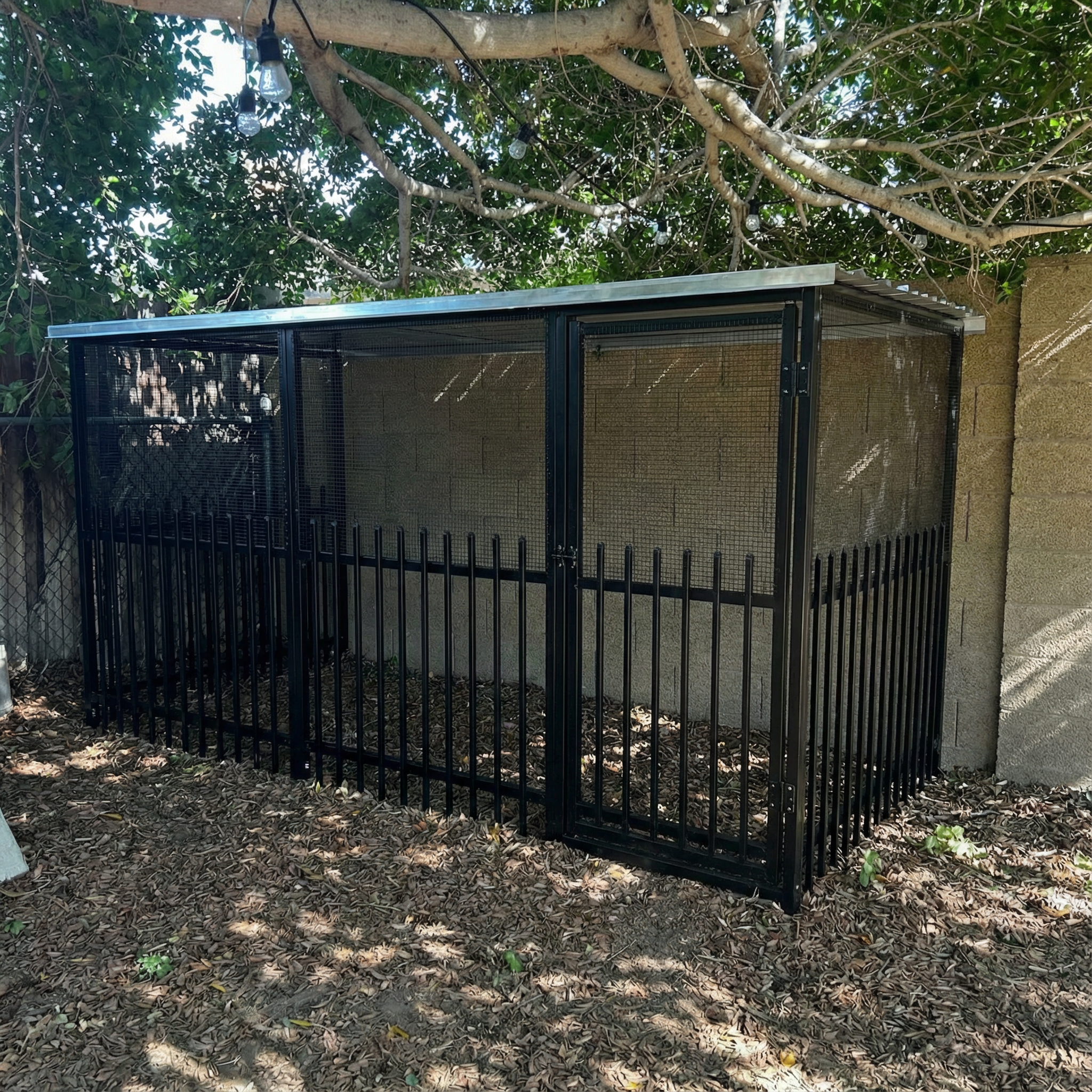 edit this image to remove the pallet fencing and place a chicken coop in this space which is constructed of 4 ft. H x 12 ft. x 6ft W Black Aluminum Pre-Assembled Flat Top Spaced Picket Fence Panel black with black 1/2 hardware cloth on top of the fencing, and silver steel galvanized sheet roofing make a door gate in the coop