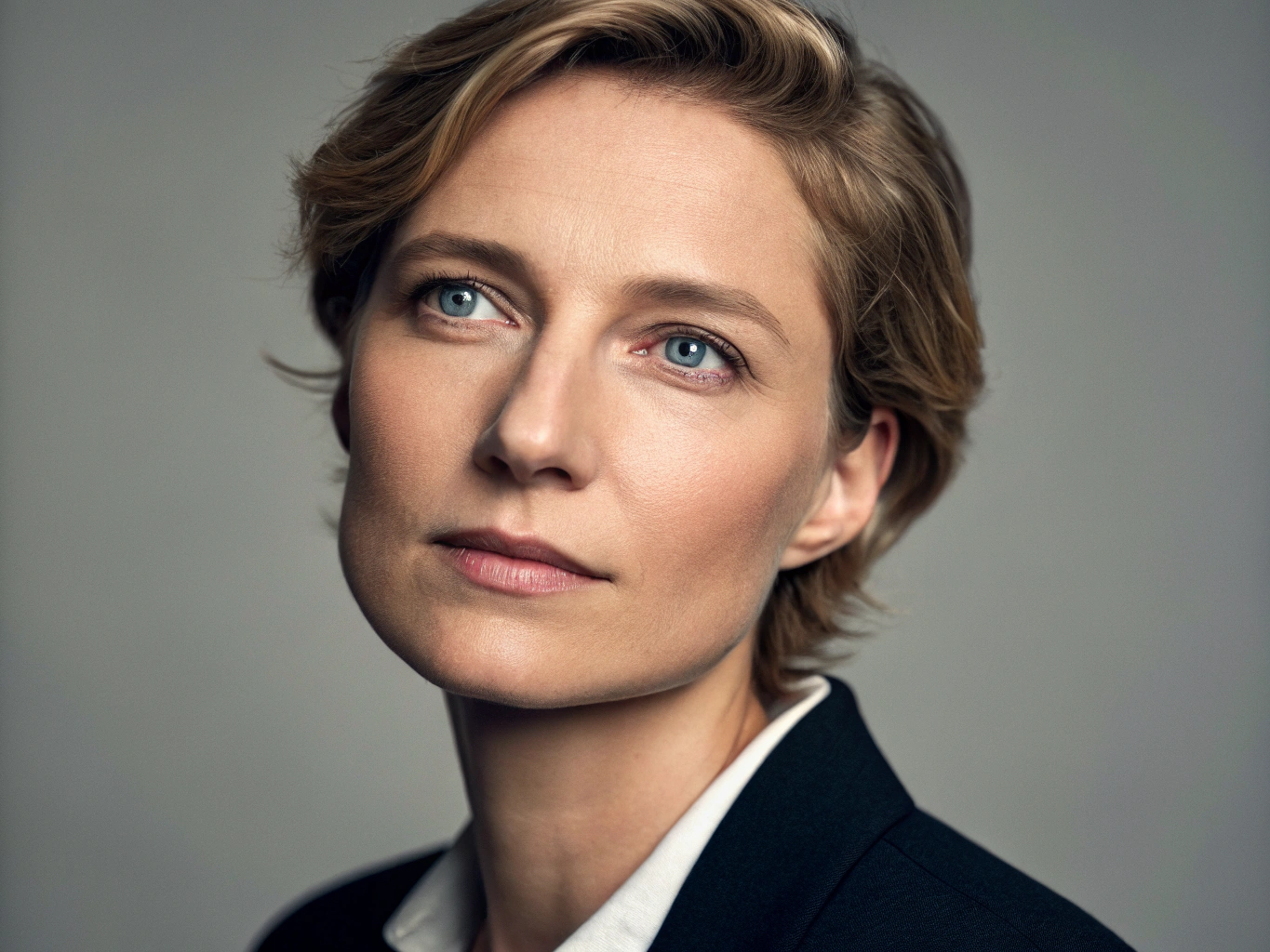 Professional headshot photograph of a person, studio lighting, sharp focus, high detail, flattering soft shadows, neutral background, suitable for LinkedIn profile
