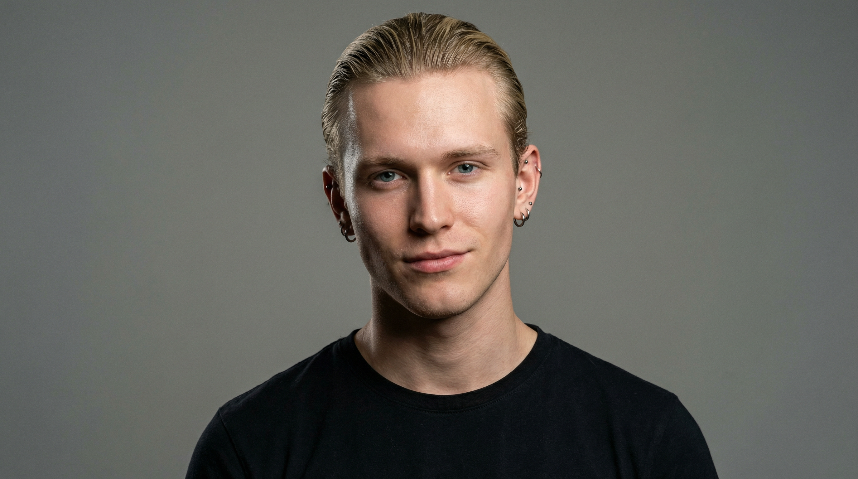 Photorealistic portrait with studio lighting.
A young caucasian man, 20 years old, clean-shaven, with hair dyed blonde and slicked back. He has blue eyes and a slight smirk.
He is wearing a black shirt.
He has piercings in his ears.